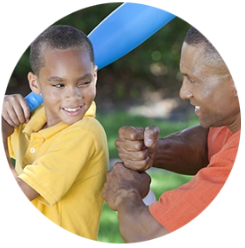 Photo of man coaching child playing baseball